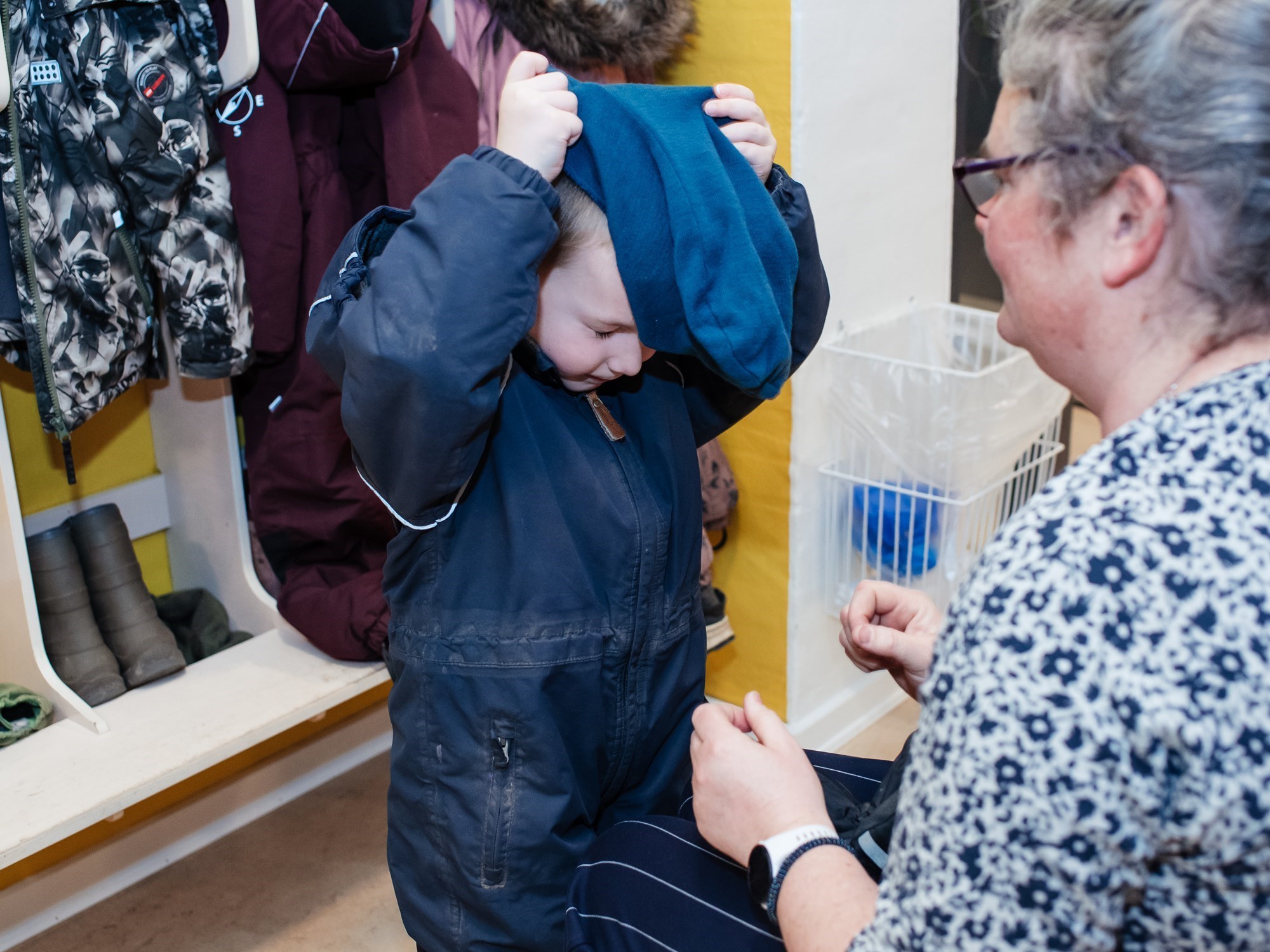 Barn, der tager overtøj på i garderobe 