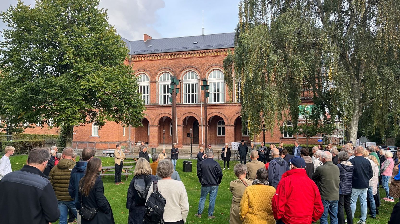 Mange mennesker på græsset foran det gamle Rådhus